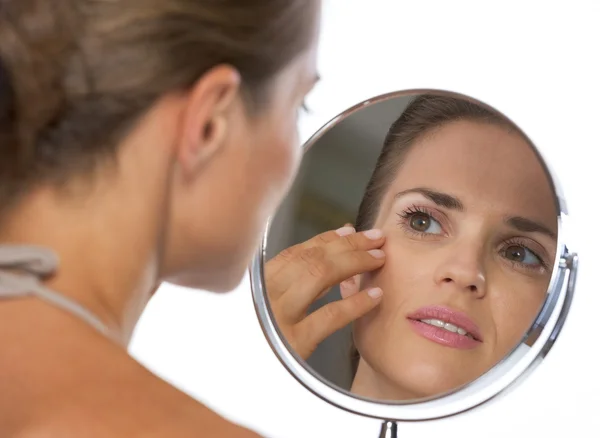 Young woman looking in mirror — Stock Photo, Image