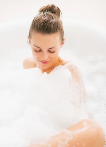 Jonge vrouw leggen in badkuip — Stockfoto