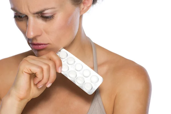 Portrait of concerned young woman with pills — Stock Photo, Image