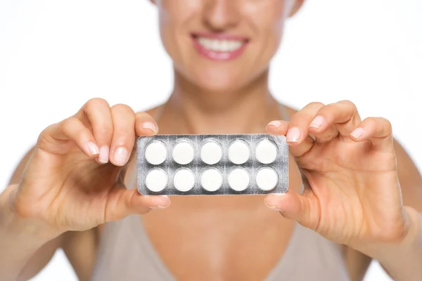 Closeup on young woman showing blistering package of pills — Stock Photo, Image