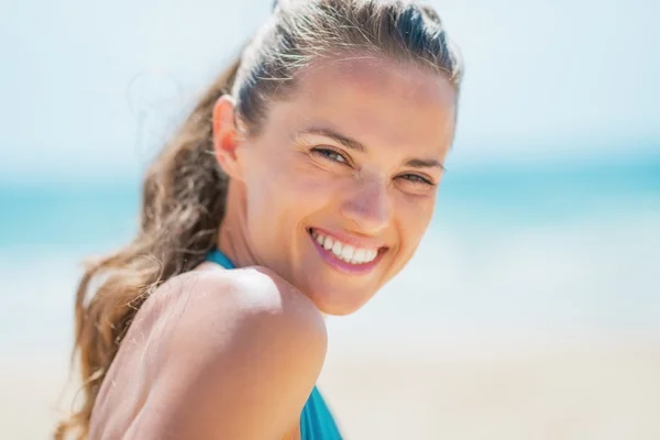 Portret van lachende jonge vrouw op strand — Stockfoto