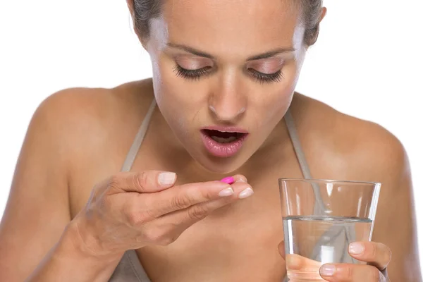 Молодая женщина ест таблетки — стоковое фото