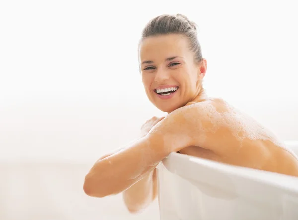 Portrait de jeune femme souriante assise dans la baignoire — Photo