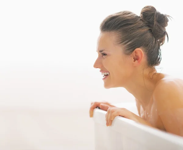 Sorridente giovane donna nella vasca da bagno in cerca di spazio copia — Foto Stock