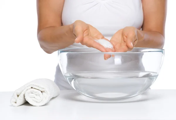 Primer plano de la joven feliz lavándose las manos en un recipiente de vidrio con agua —  Fotos de Stock