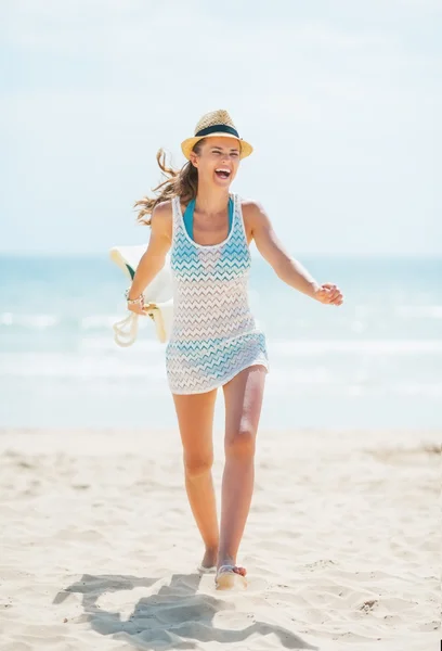 Mujer joven en sombrero y con bolsa de divertirse en la playa — Foto de Stock