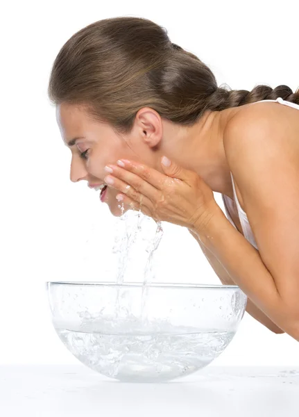 Profile portrait of happy young woman washing face in glass bowl — Stock Photo, Image