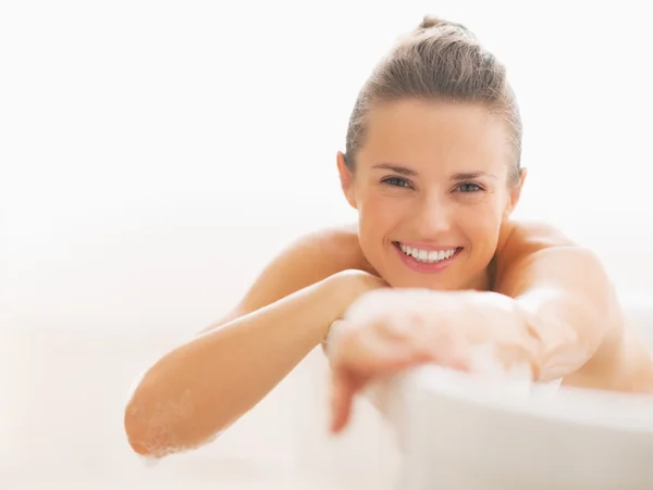 Lachende jonge vrouw die zit in badkuip — Stockfoto