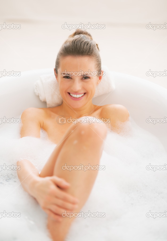 Smiling young woman relaxing in bathtub