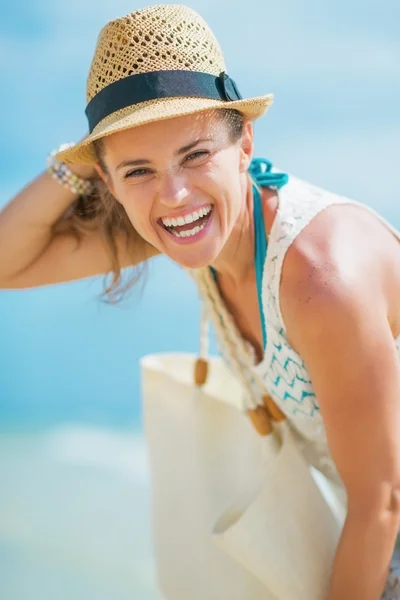 Portret van een jonge vrouw met hoed en zak op zee — Stockfoto