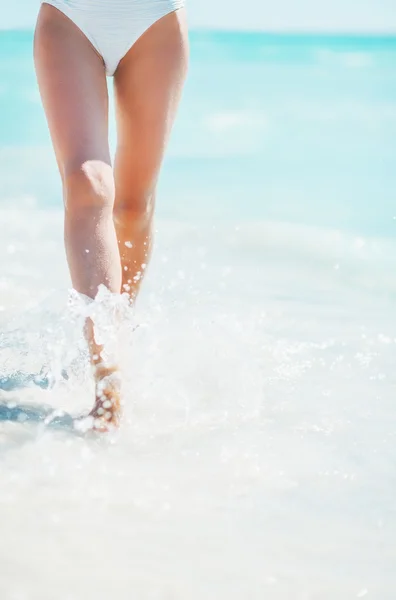 Nahaufnahme einer jungen Frau, die am Meer spaziert — Stockfoto