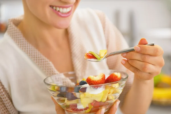 Nahaufnahme einer jungen Hausfrau, die frischen Obstsalat isst — Stockfoto