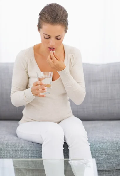 Jonge huisvrouw eten pillen — Stockfoto