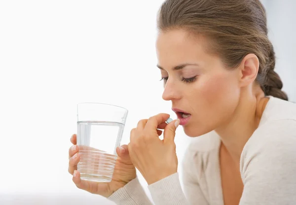 Mujer joven comiendo pastillas — Foto de Stock