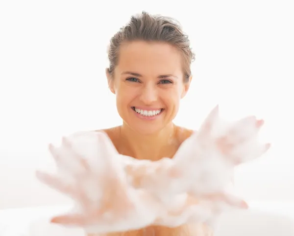 Sorrindo jovem mulher mostrando as mãos em espuma — Fotografia de Stock