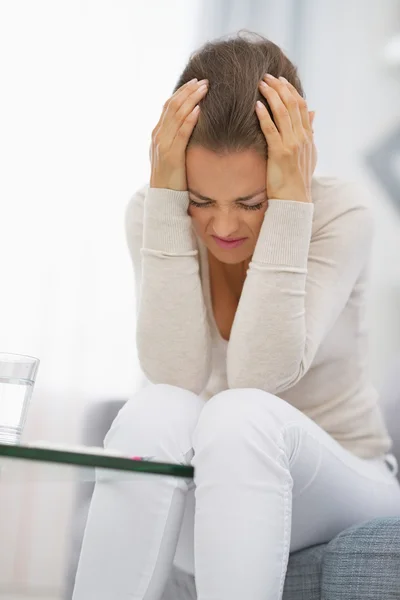 Stressed young woman sitting on couch — Stock Photo, Image