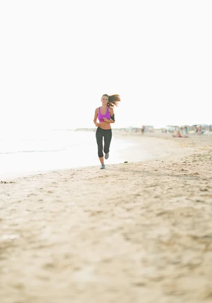 Plajda çalışan genç kadın fitness — Stok fotoğraf