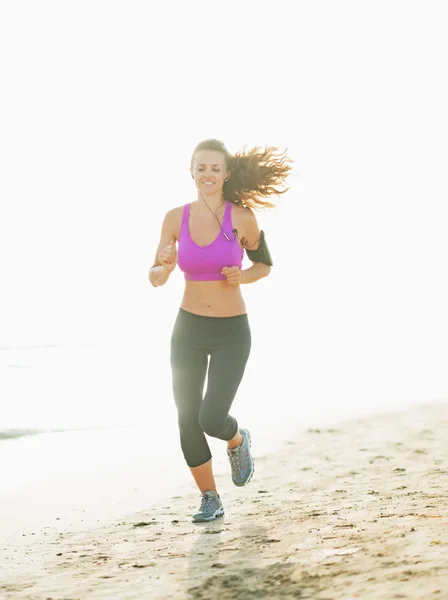 Mujer joven y saludable corriendo en la playa —  Fotos de Stock