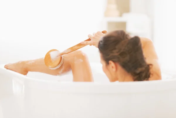 Ung kvinna tvätt i badkar — Stockfoto