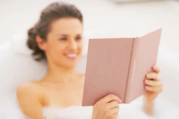 Primo piano sulla giovane donna che legge il libro nella vasca da bagno — Foto Stock