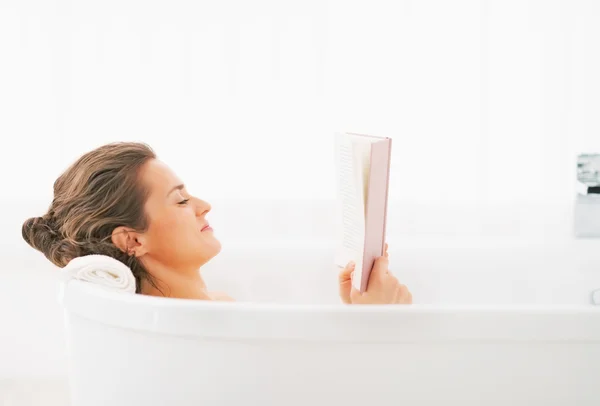 Jeune femme livre de lecture dans la baignoire — Photo