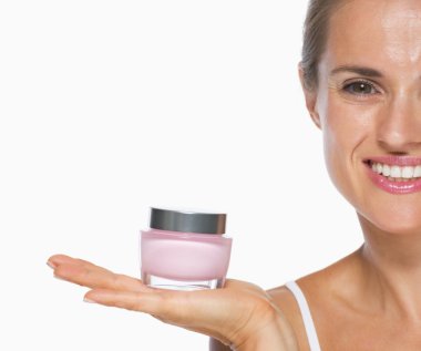 Creme gösteren gülümseyen genç kadın