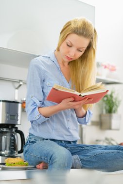 kadın mutfakta kitap okumak