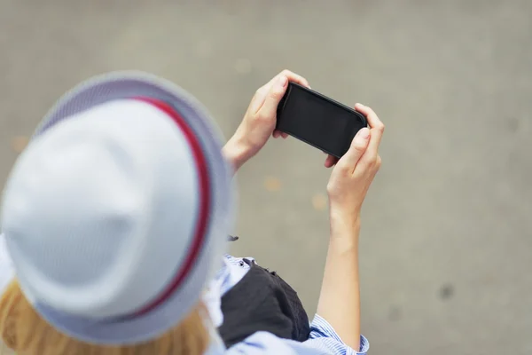 Jonge hipster schrijven sms op stad straat — Stockfoto