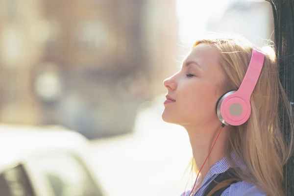 Femme écouter de la musique en ville — Photo