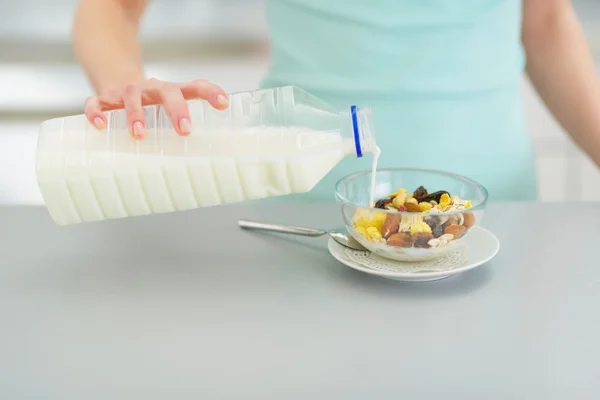 Vrouw gieten melk in muesli — Stockfoto
