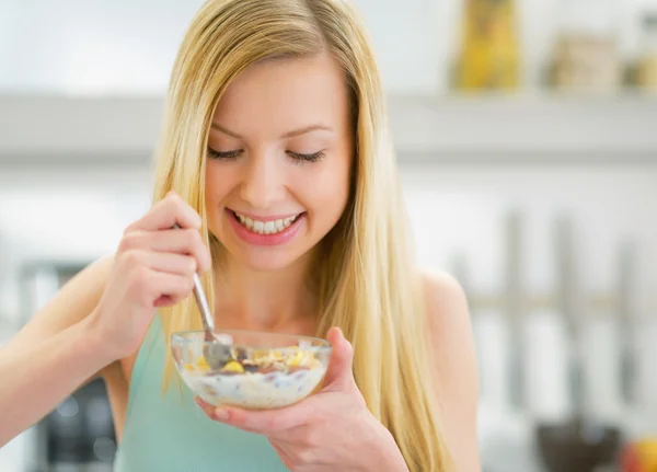 Frau isst Müsli in Küche — Stockfoto