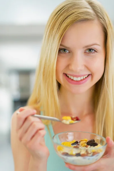 Woman eating muesli in kitchen — Stock Photo, Image