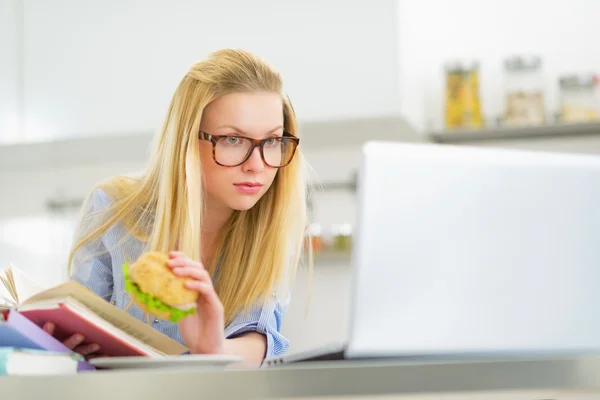 Młoda kobieta studia w kuchni — Zdjęcie stockowe