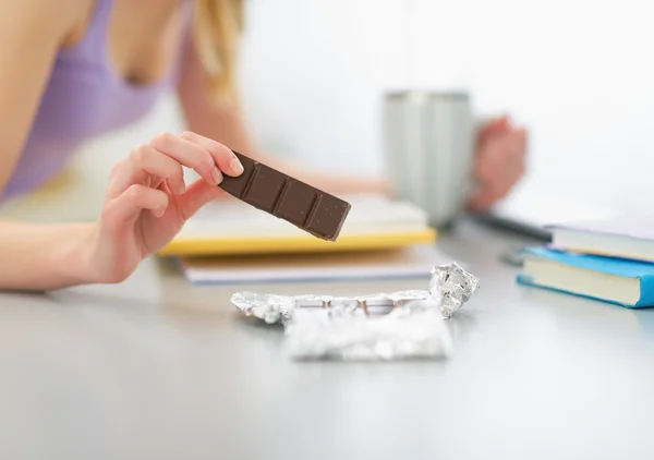 Teenager girl eating chocolate and studying — Stock Photo, Image