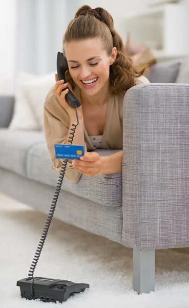 Mulher com cartão de crédito falando telefone — Fotografia de Stock