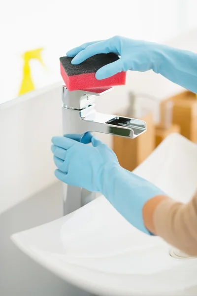 Huisvrouw schoonmaak kraan in badkamer — Stockfoto