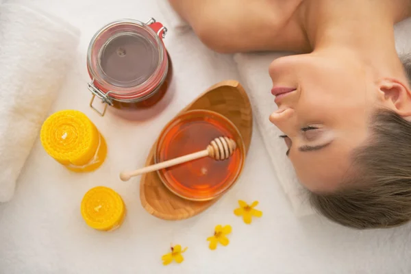 Vrouw in de buurt van honing spa therapie ingrediënten — Stockfoto