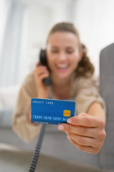 Femme heureuse avec téléphone parlant carte de crédit — Photo