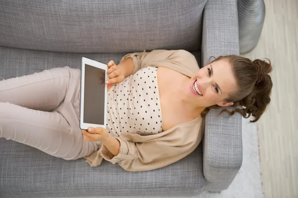 Mulher feliz no sofá com tablet — Fotografia de Stock