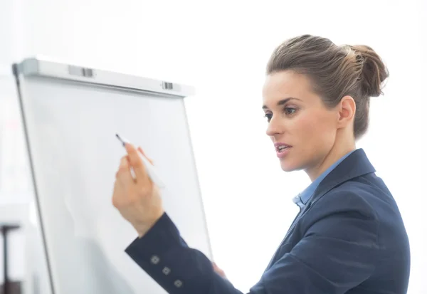 Geschäftsfrau schreibt auf Flipchart — Stockfoto