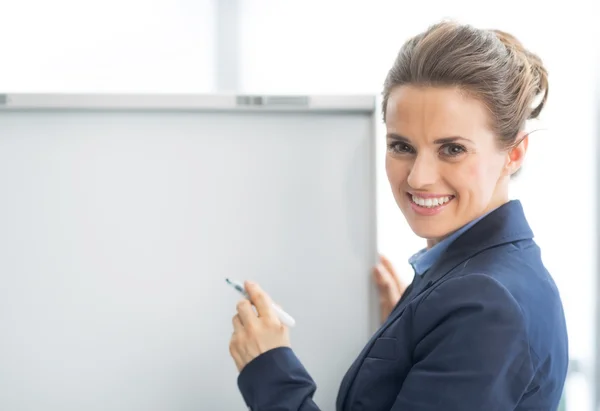 Glückliche Geschäftsfrau in der Nähe von Flipchart — Stockfoto