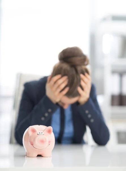 Piggy bank and stressed business woman — Stock Photo, Image