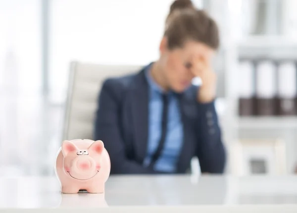 Piggy bank and stressed business woman — Stock Photo, Image