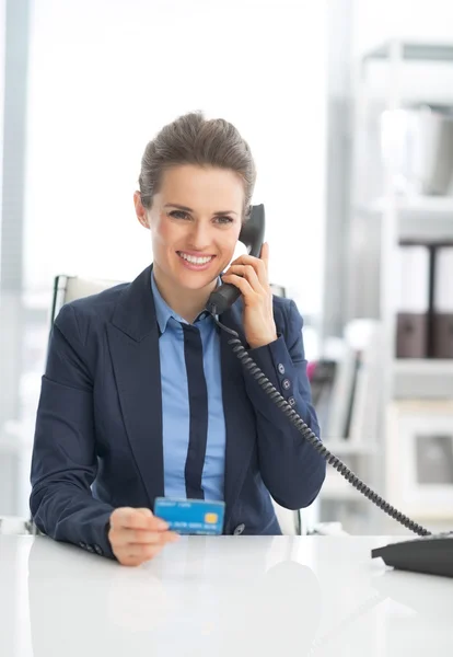 Business woman with credit card talking phone — Stock Photo, Image