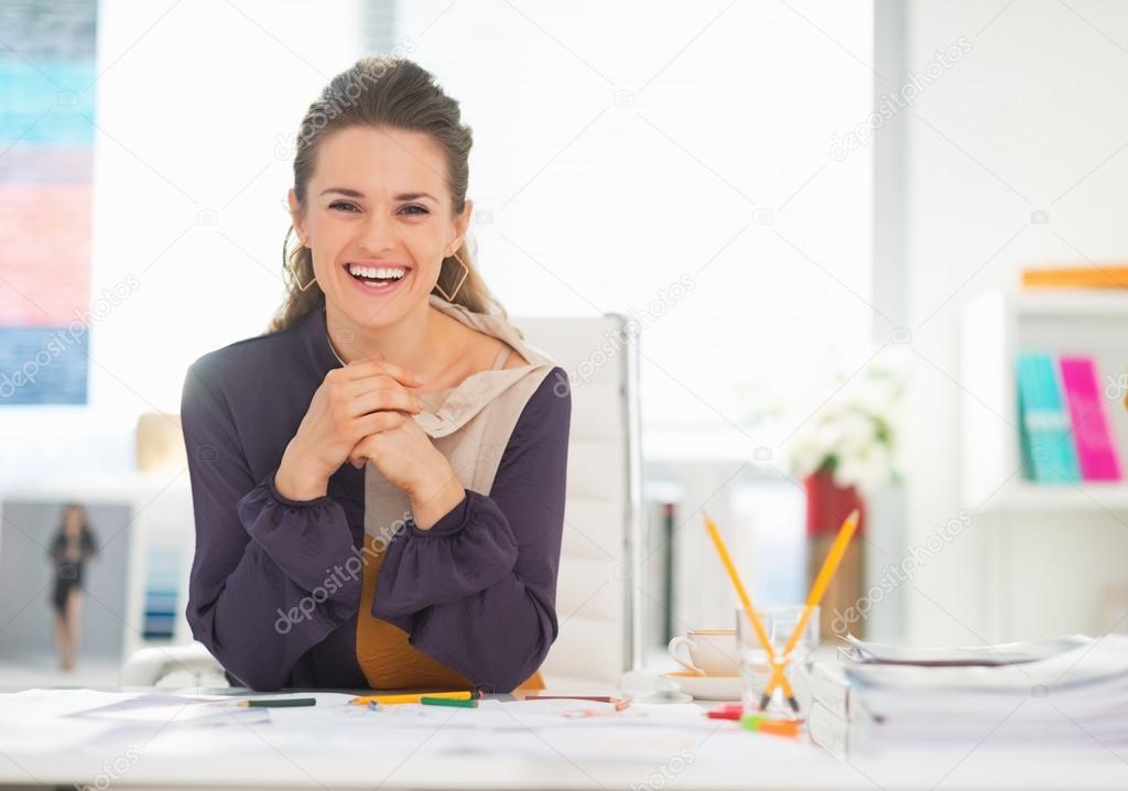 Smiling fashion designer in office