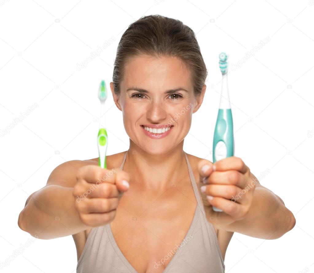 Woman showing old and electric toothbrush