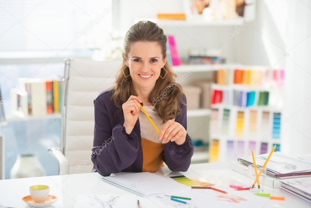 Smiling fashion designer in office