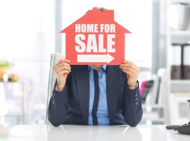 ev satışı işareti için tutan emlakçı kadın
