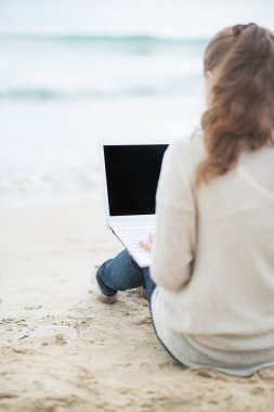laptop soğuk sahilde bir kadınla