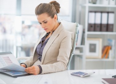 Ofisinde evrakları olan bir iş kadını.